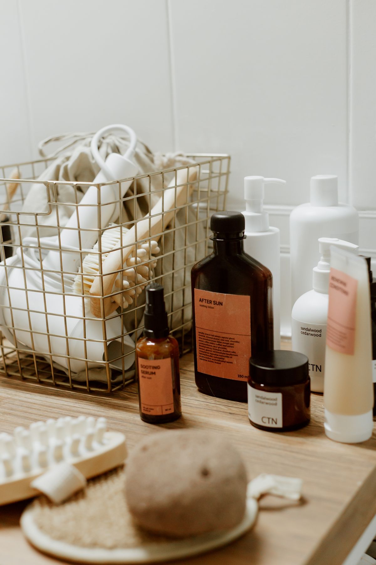 Elegant bathroom setup featuring various cosmetic bottles and a basket holding toiletries.