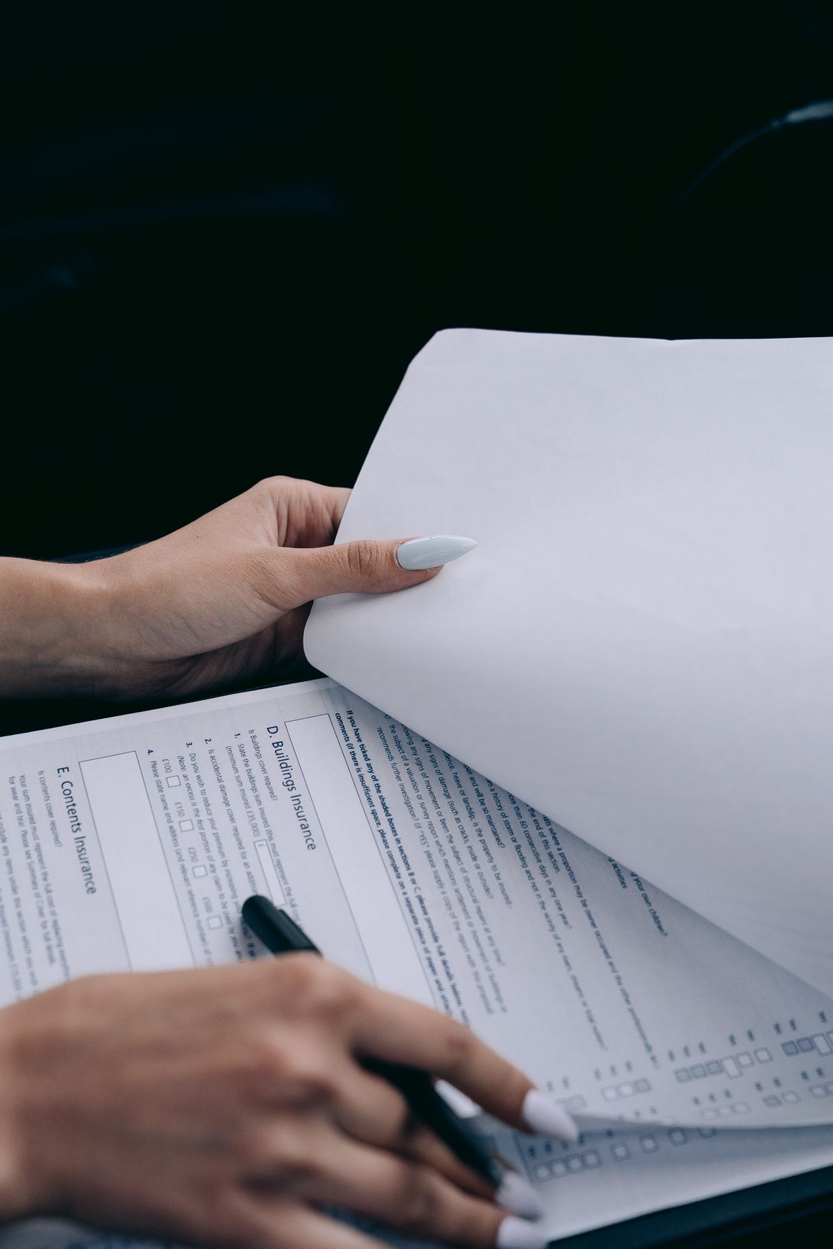 Detailed view of a person holding documents and a pen, ideal for business content.