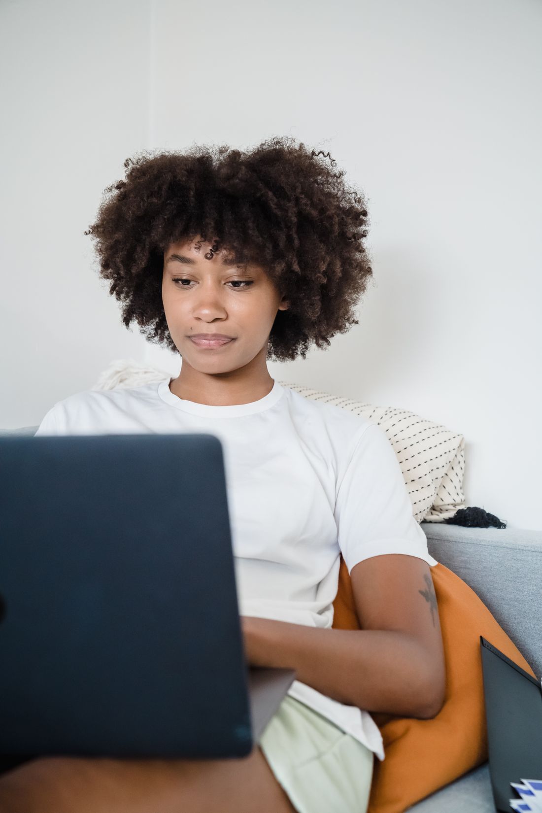 A woman focusing on her laptop in a casual workspace.