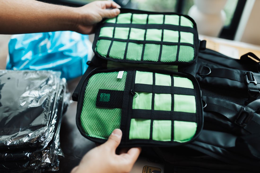 Hands organizing travel luggage with packing compartments.