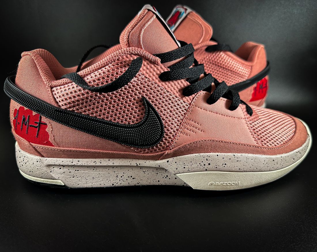 Pink athletic sneakers with dark laces and textured soles.