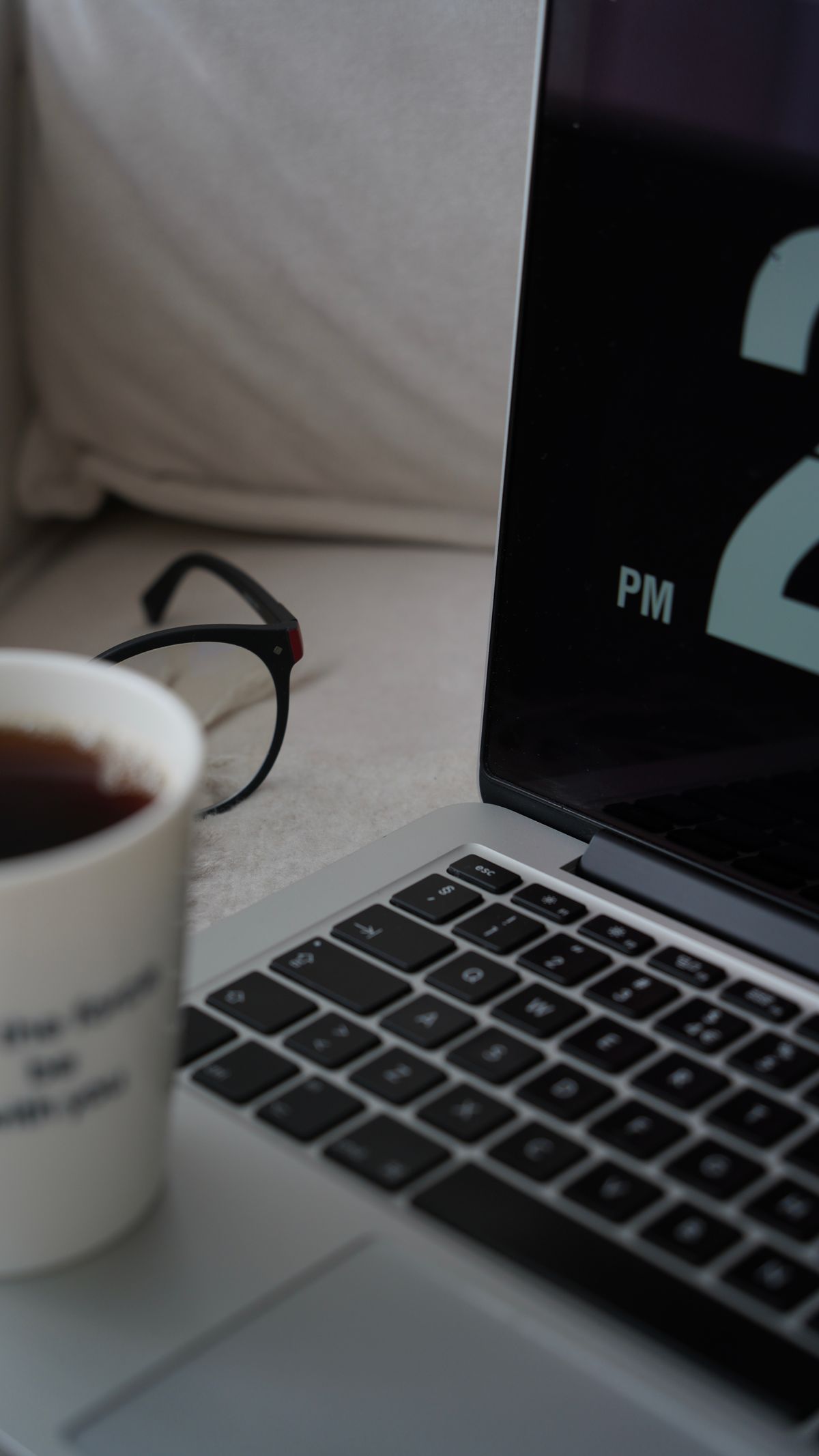 Cozy home office scene with coffee, laptop, and eyeglasses. Perfect for remote work inspiration.
