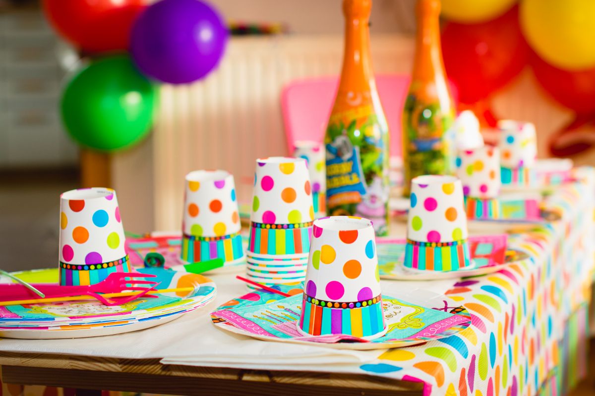 Colorful party table setup with polka dot cups and balloons, perfect for celebrations.