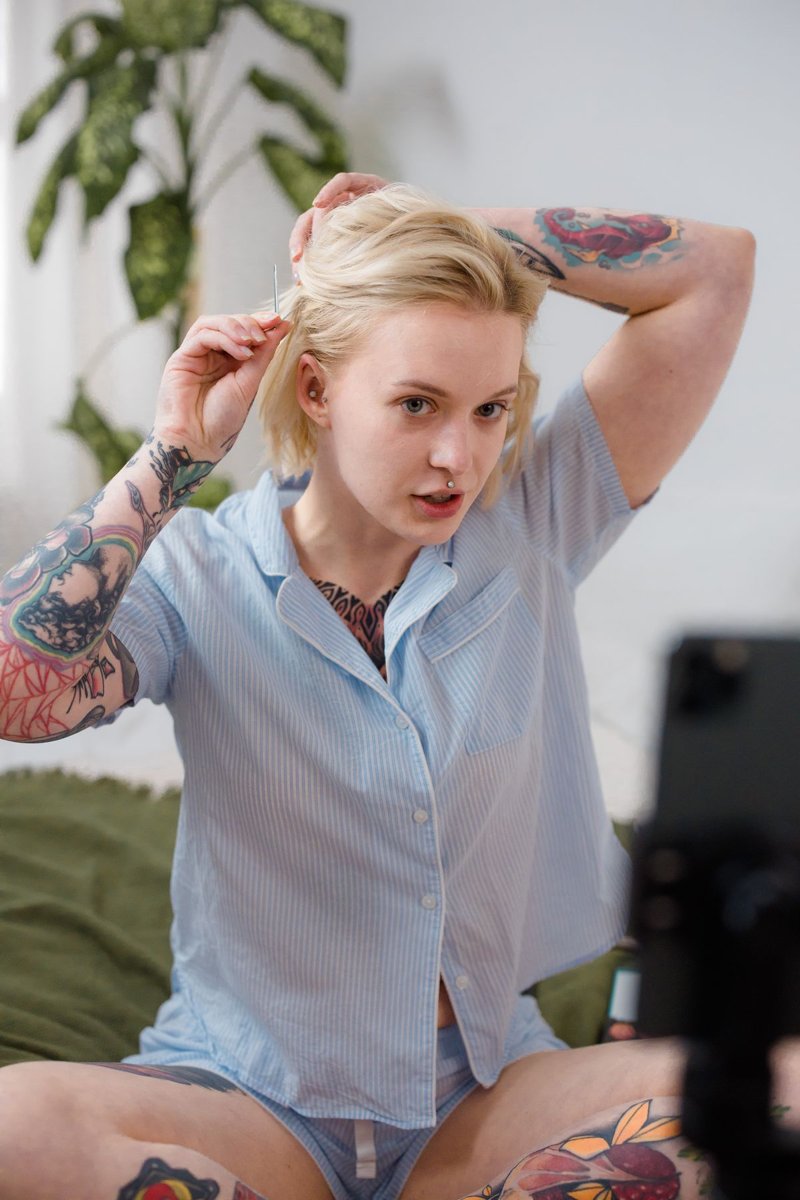 A woman securing her gathered hair with a clip.