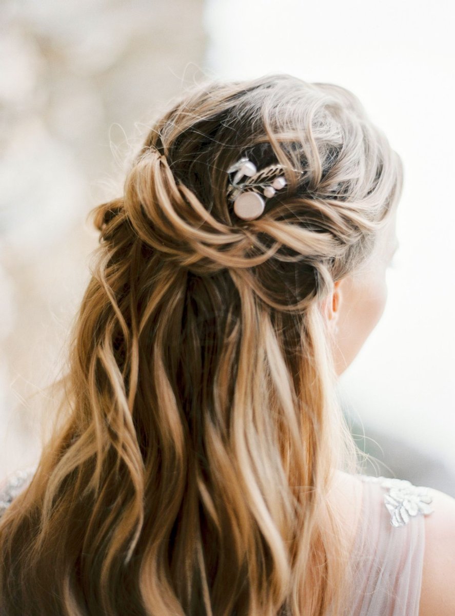 Rear view of long blonde hair with an upper section secured by a decorative clip.