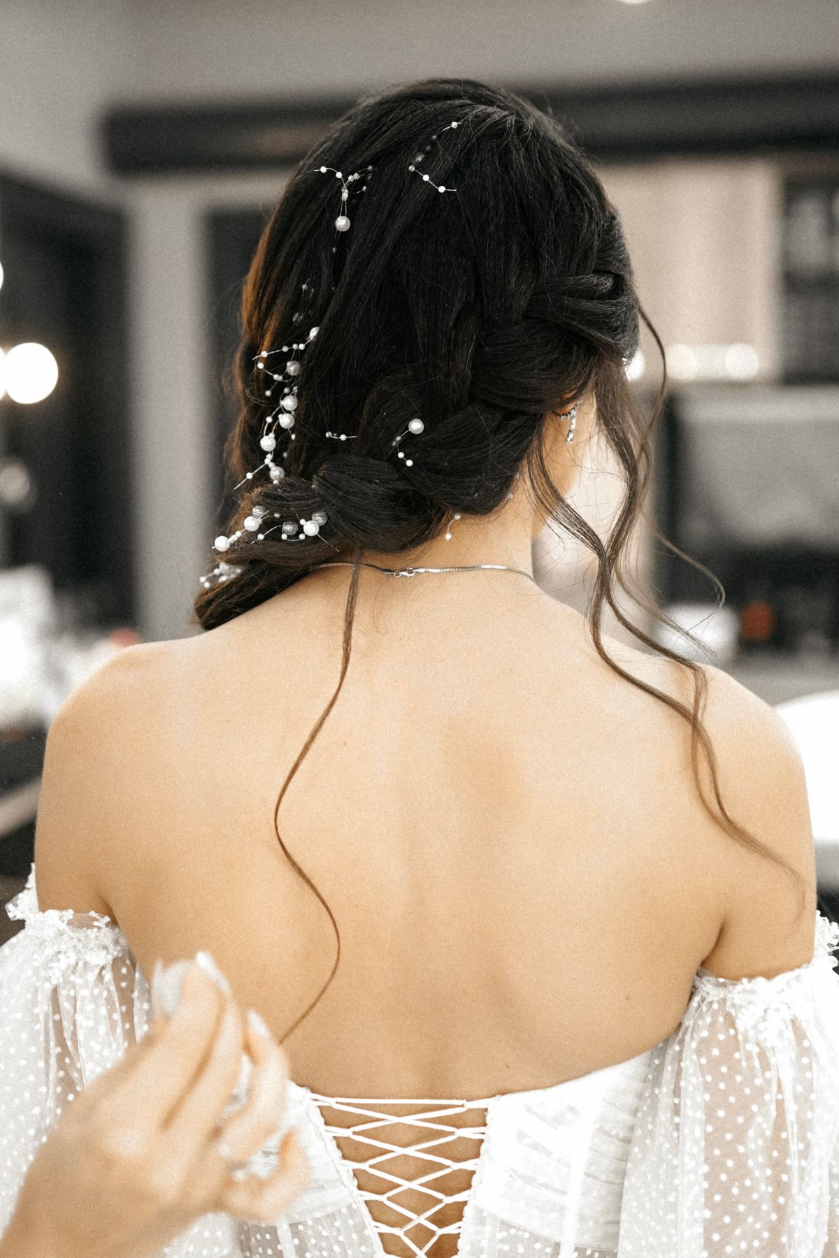 Rear view of a bride's elegant hairstyle adorned with floral accessories, perfect for wedding inspiration.