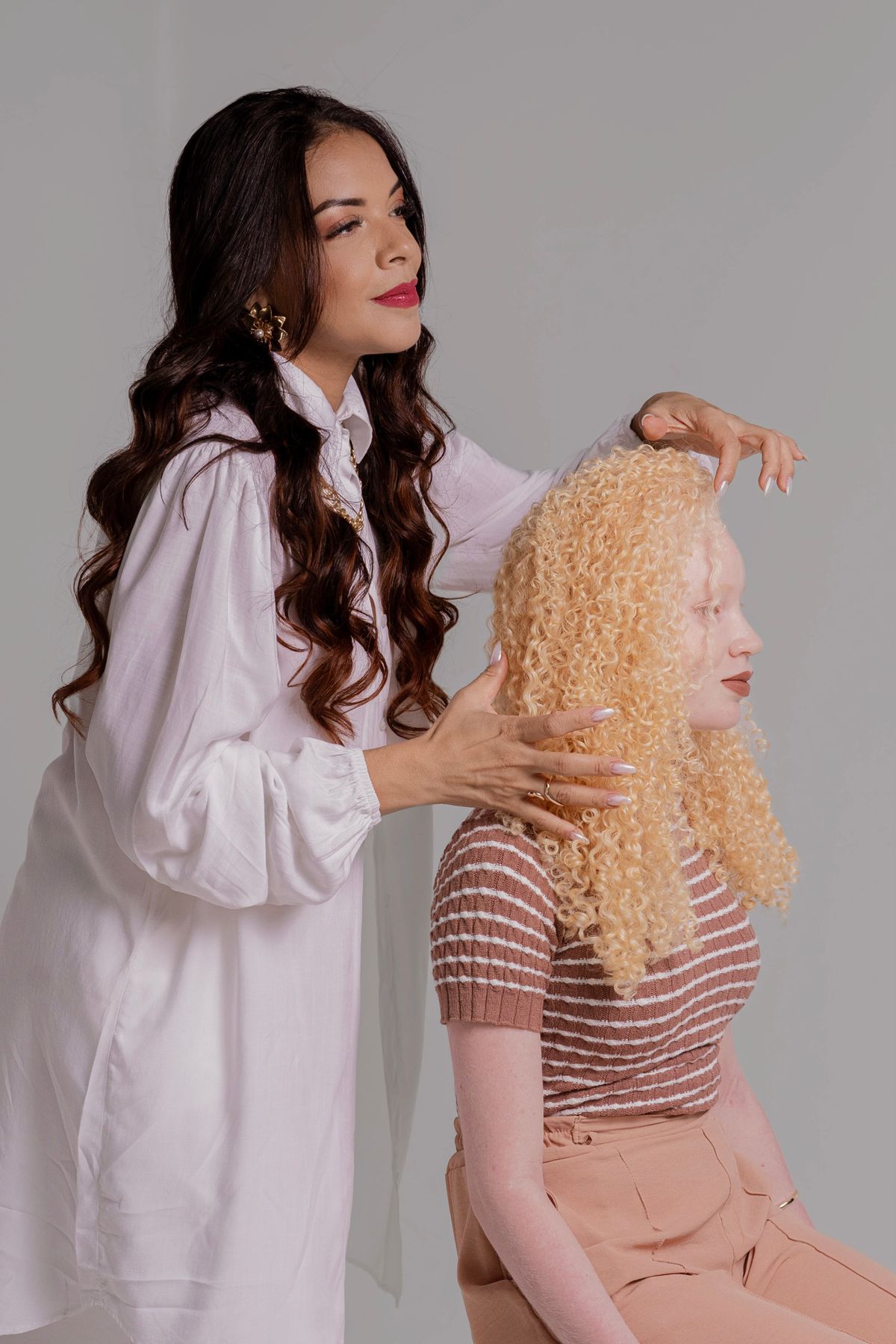 Hair stylist working on diverse women's hairstyles in a studio setting.