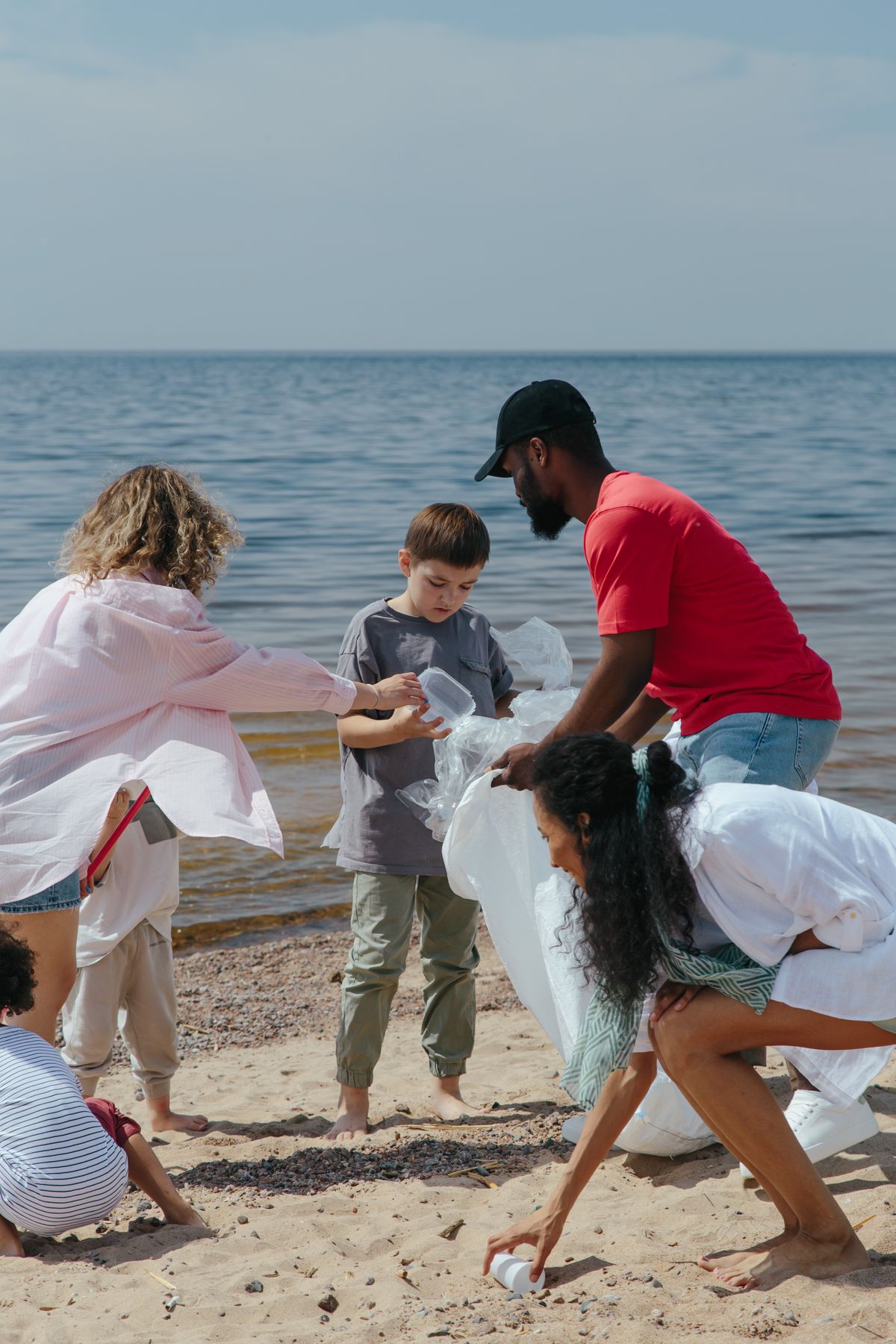 A diverse group of volunteers cleaning a beach, promoting environmental awareness.