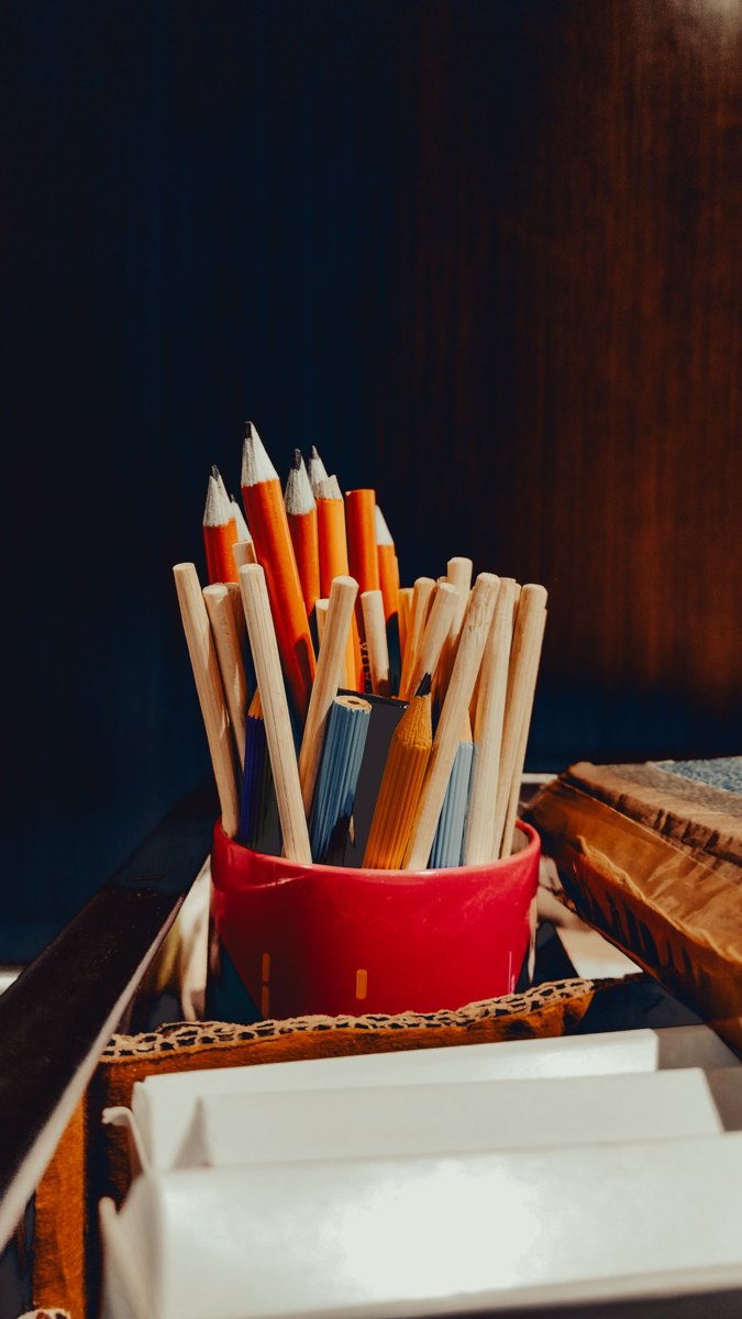 An assortment of pencils in a red holder.