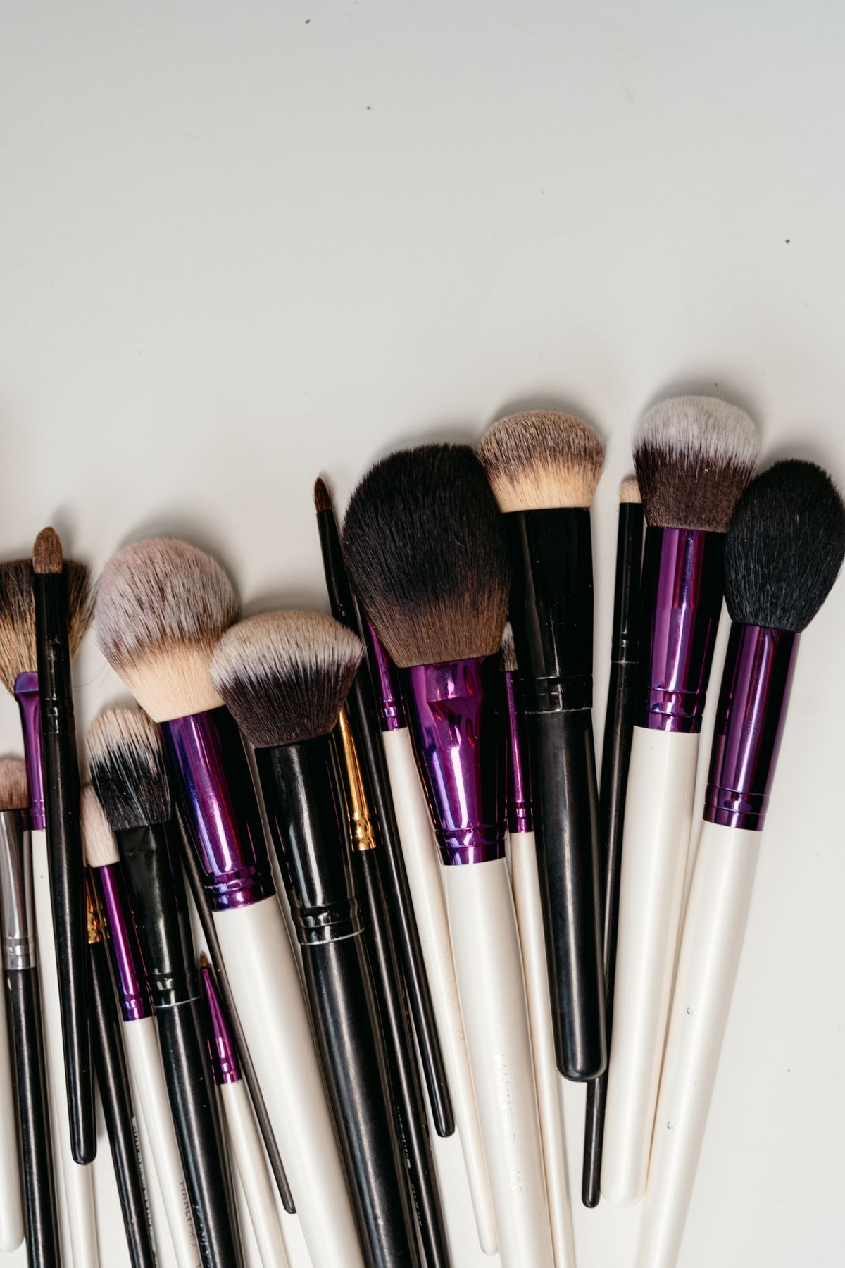 Assorted makeup brushes with black and white handles for cosmetics application.