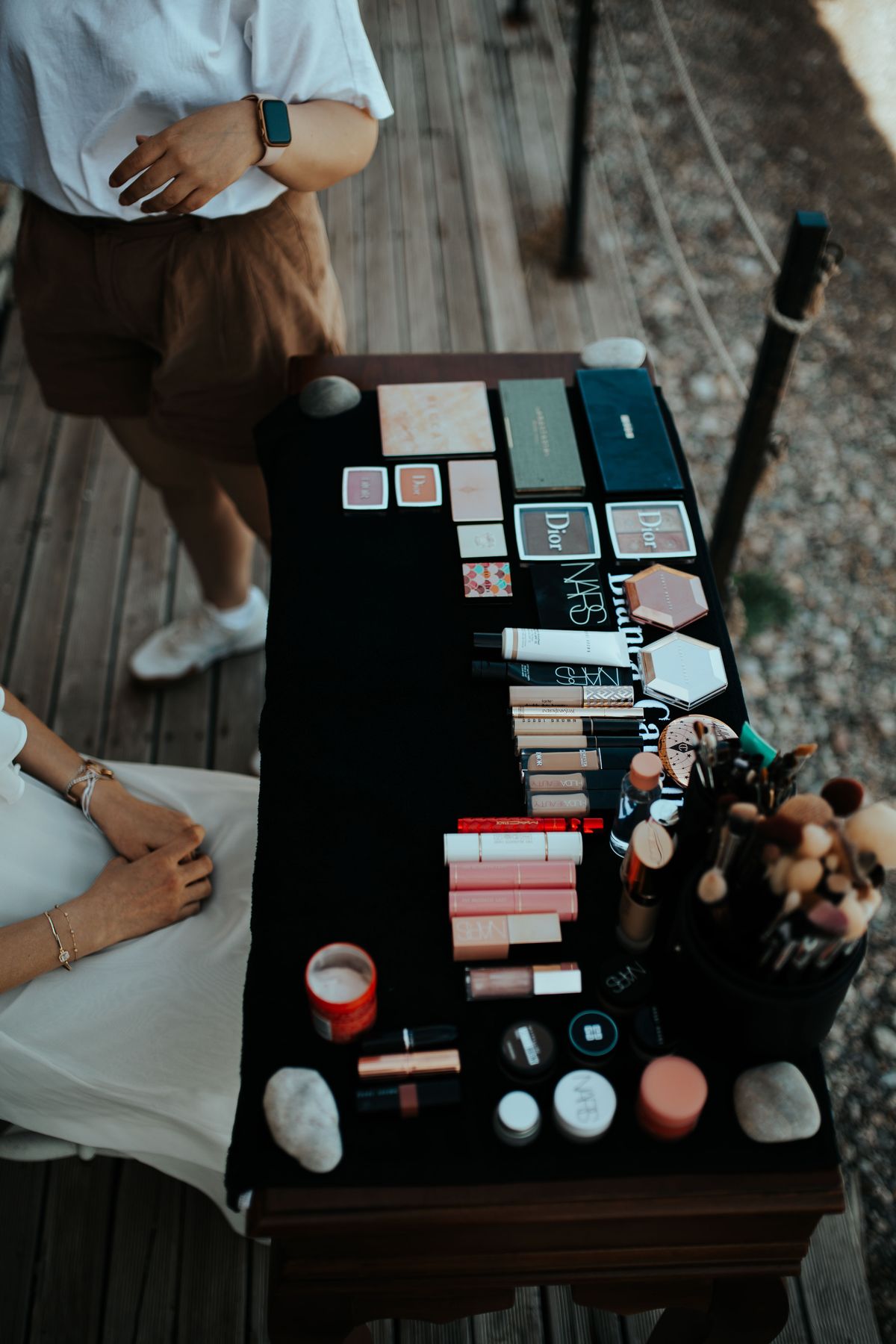 Top view of various makeup products on a table outdoors in Muğla, Türkiye.