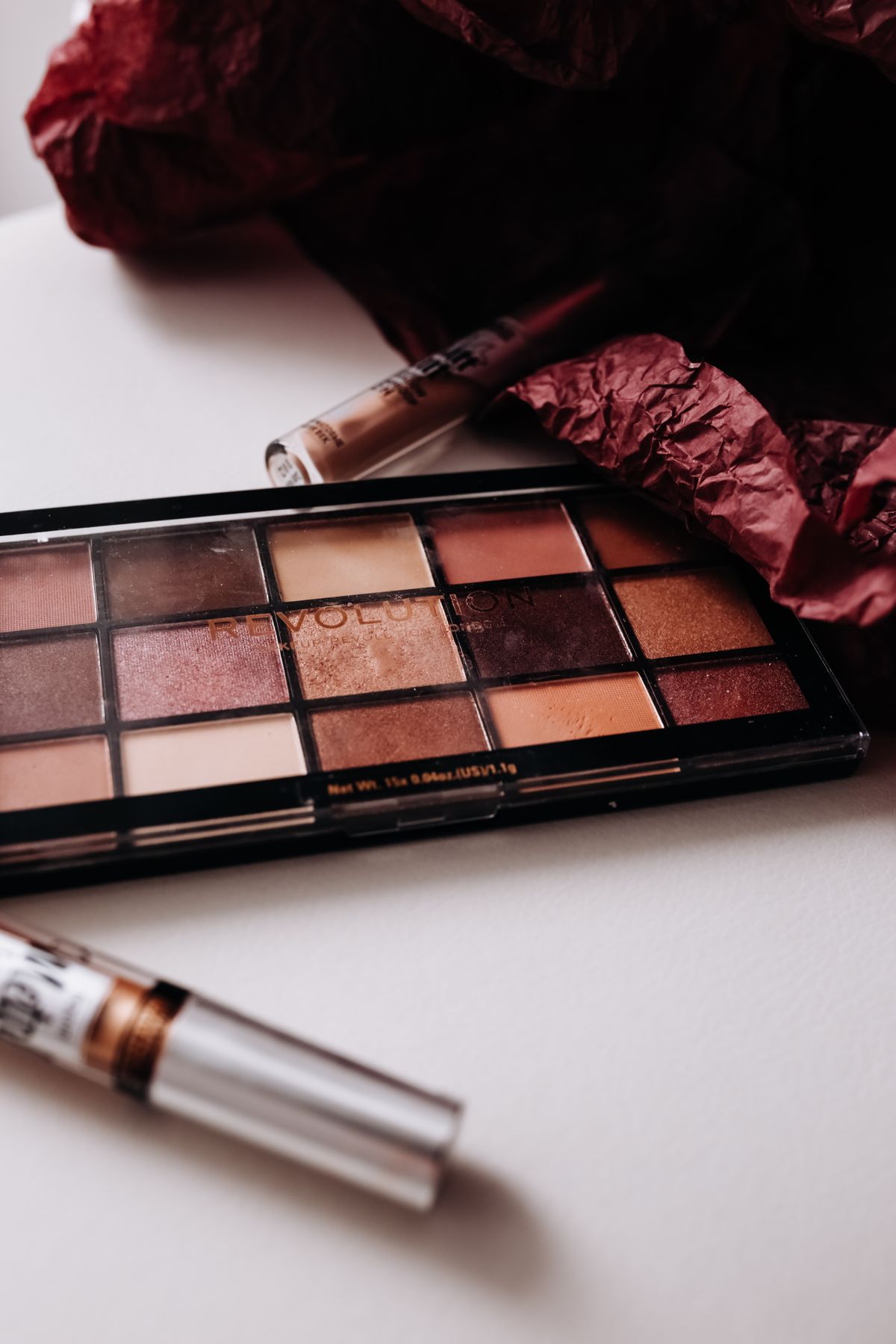 Vibrant eyeshadow palette with brushes on a minimalist white background.