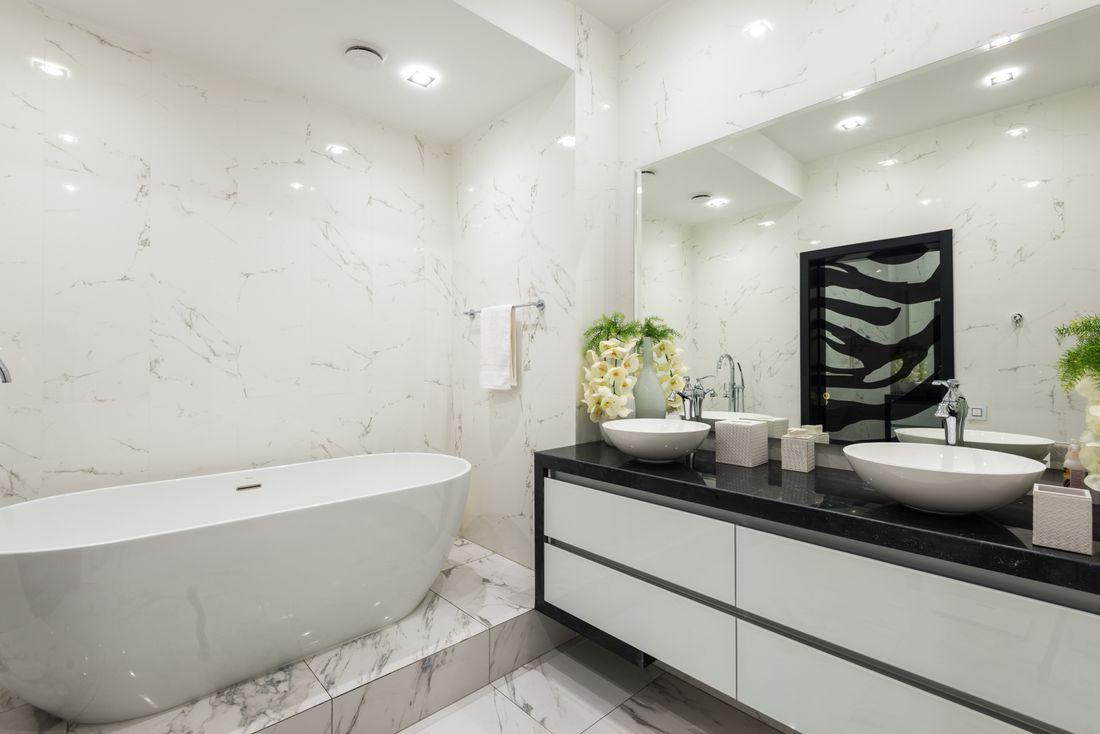 A bathroom with a cabinet underneath the sink.