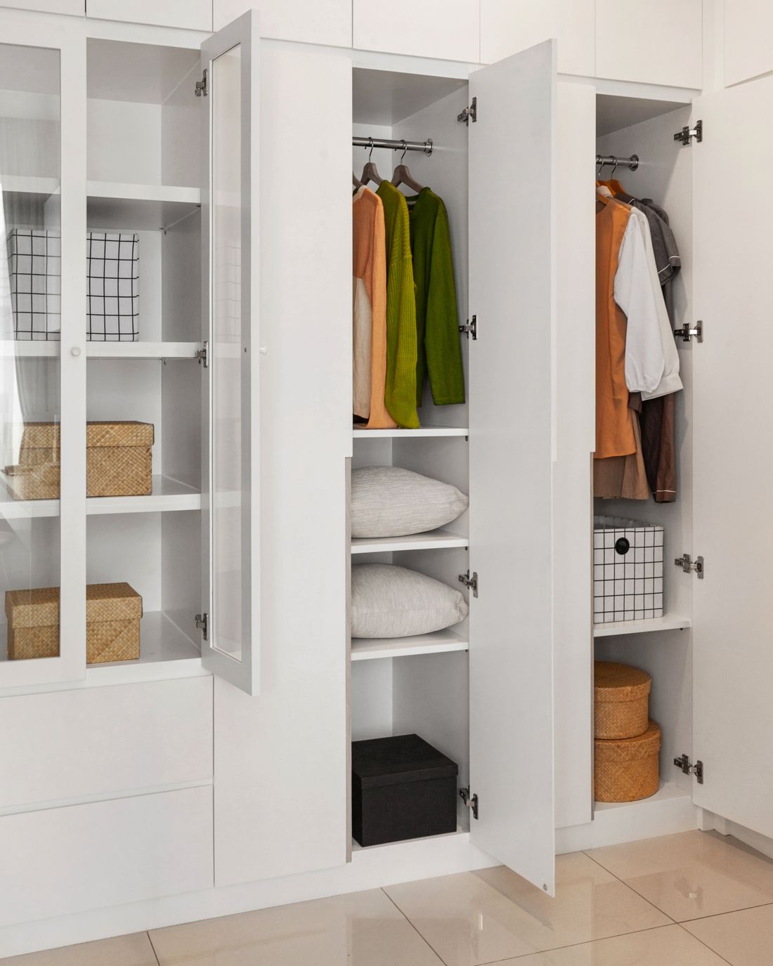 Clothes and storage arranged inside a wardrobe.