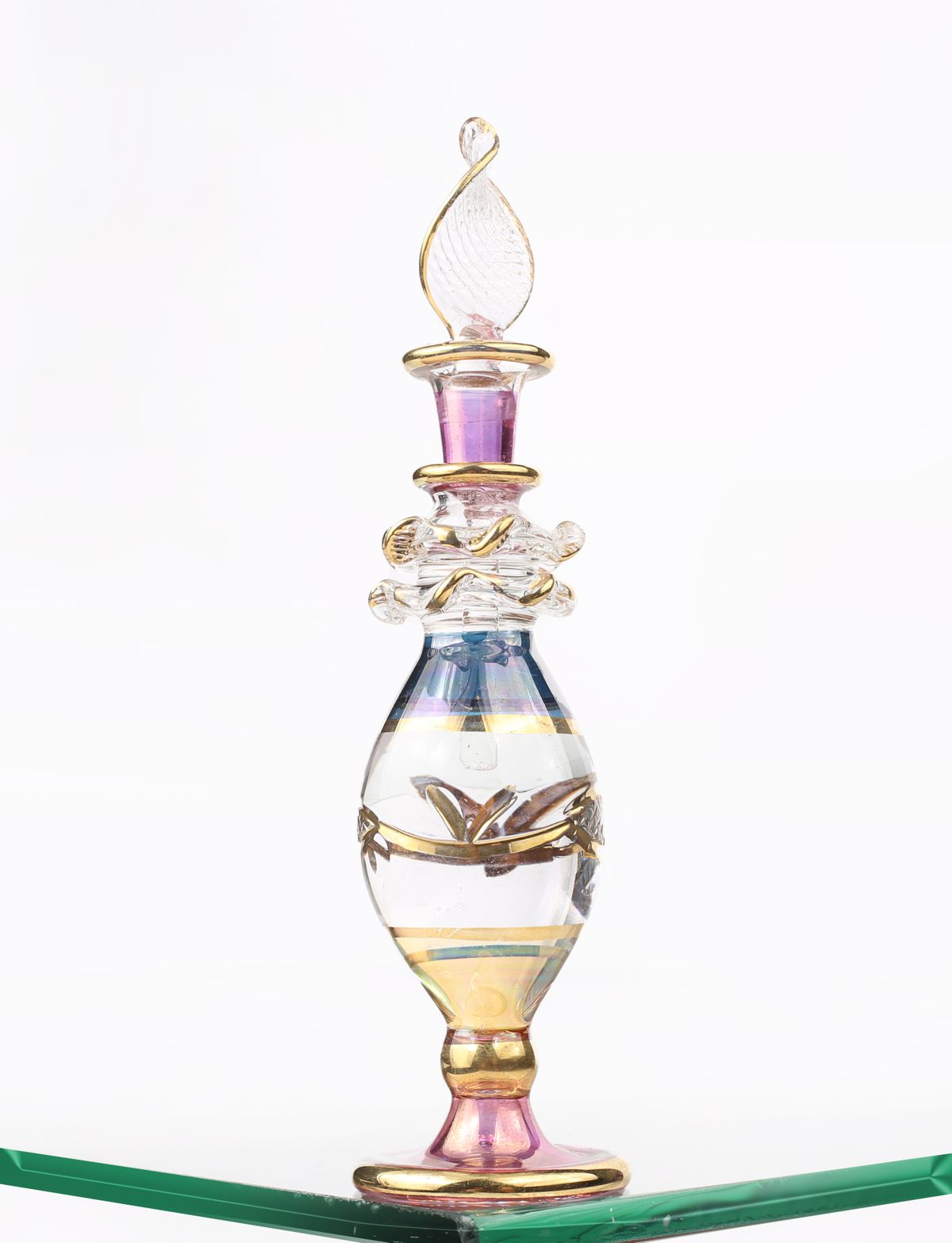 Ornate glass perfume bottle with gold accents on a clear surface. Ideal for lifestyle and fashion themes.