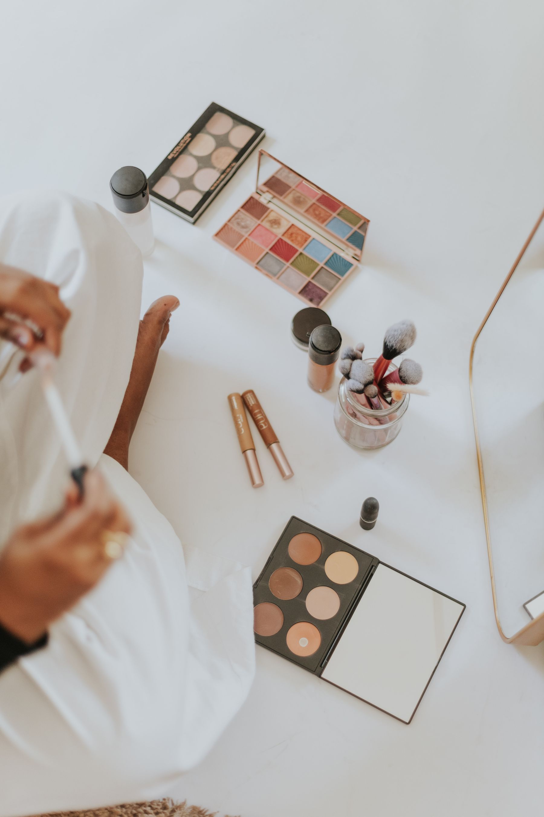 Real makeup palettes and brushes on a white table