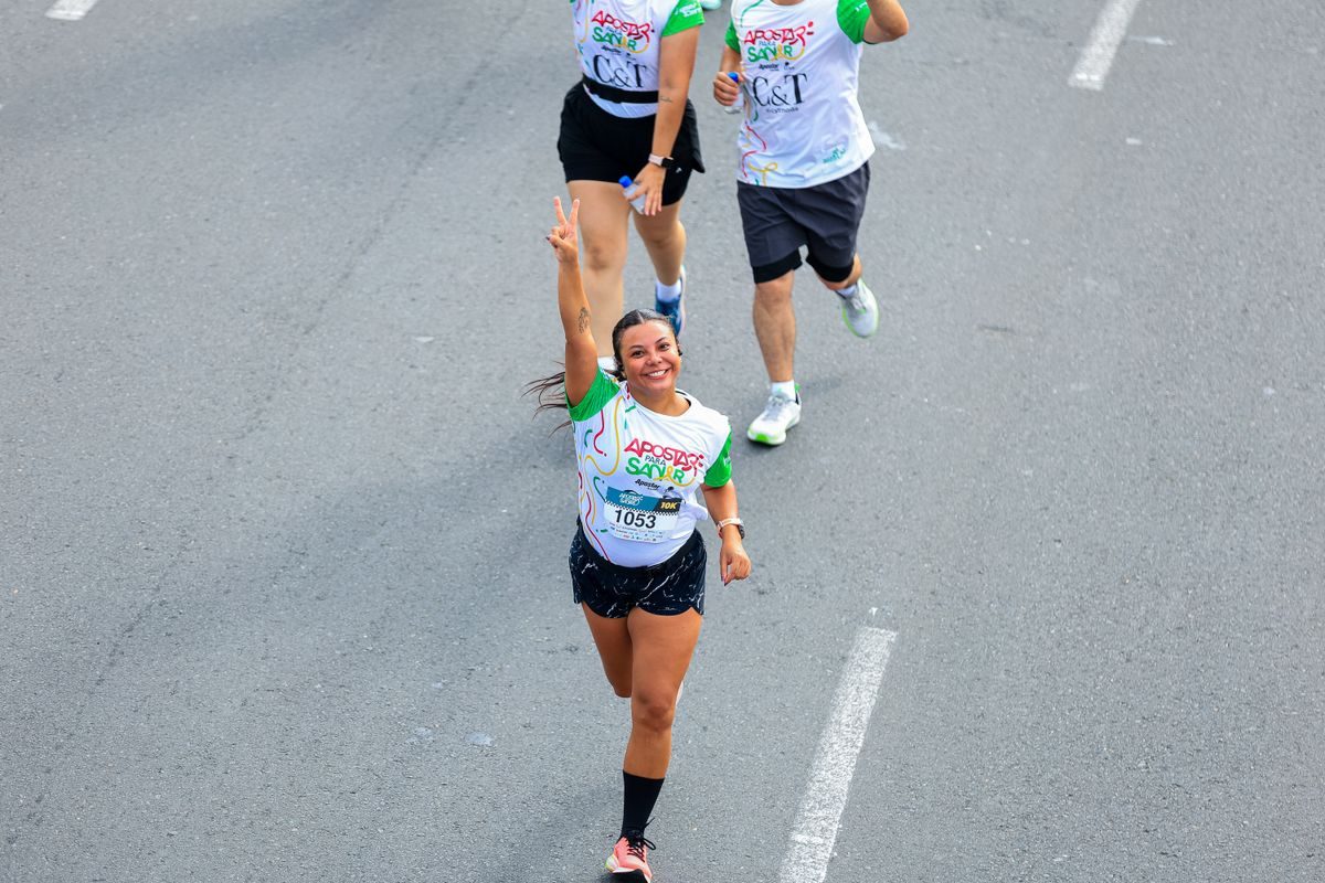 Smiling runners participating in an outdoor road race.