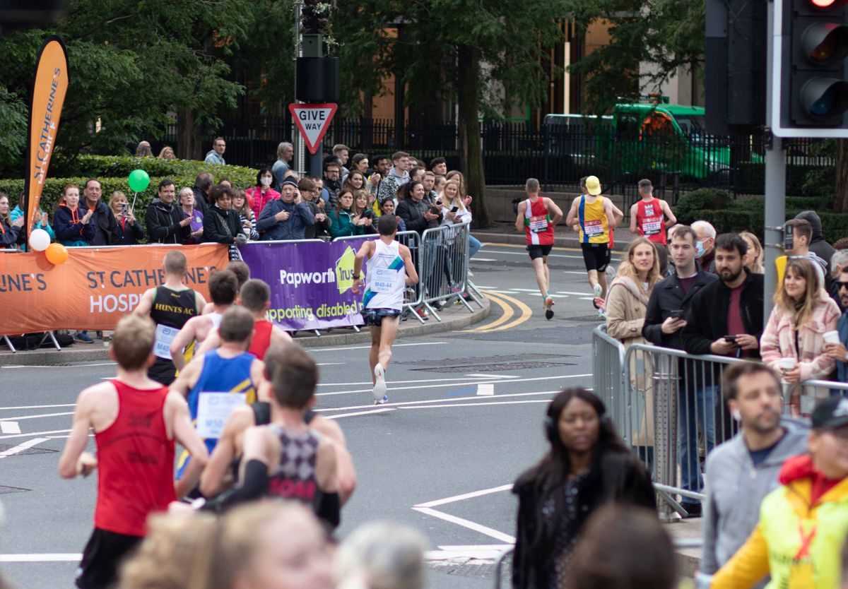 Spectators watching runners on a London street.