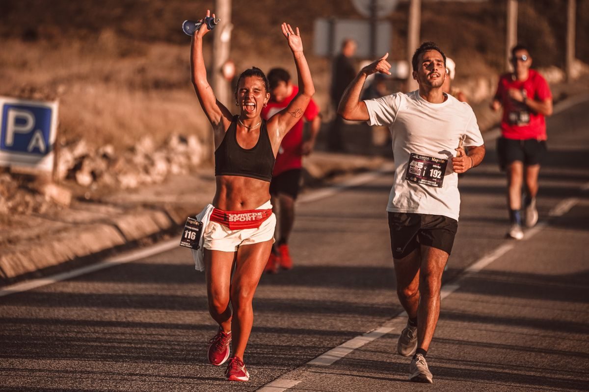 Runners smiling during a sunny road race.