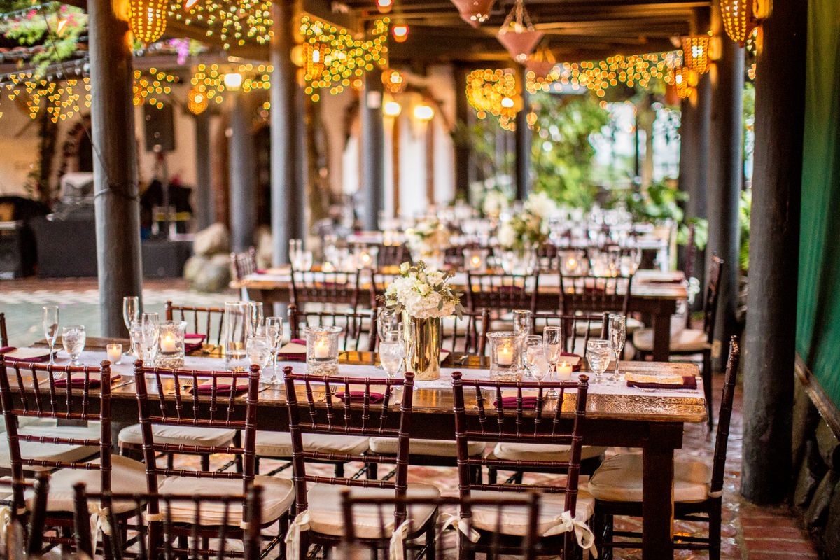 Charming outdoor dining setup with warm bistro lights and floral centerpieces.