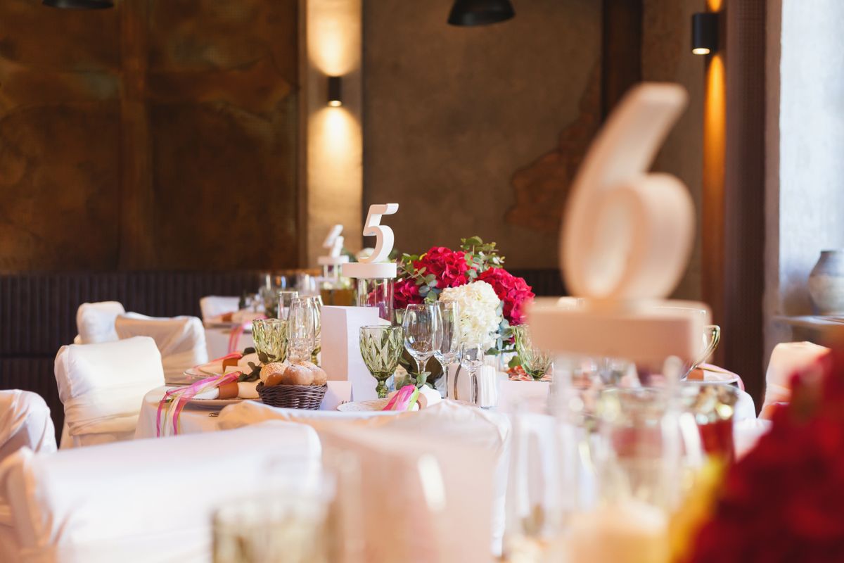 Elegant table setting for a special event featuring floral centerpieces and decorative table numbers.