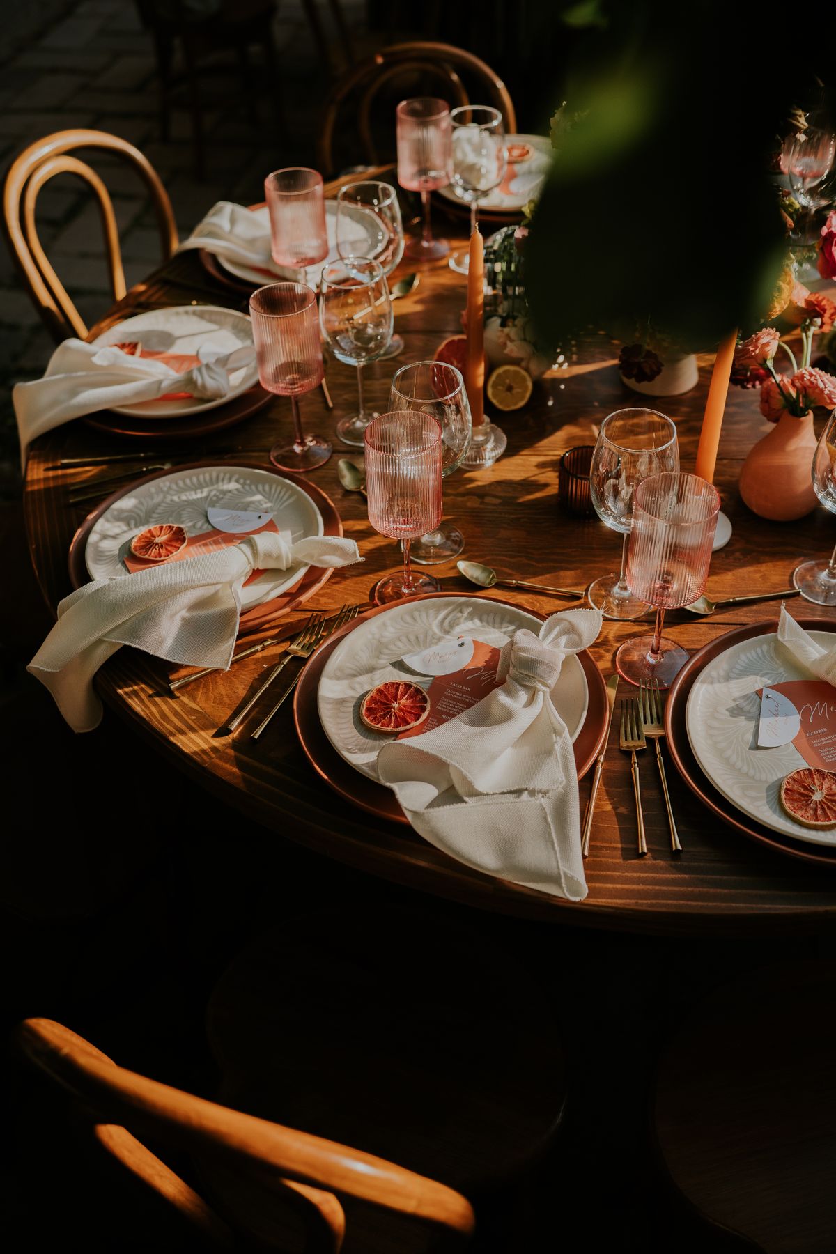 A beautifully arranged table for a wedding with elegant glassware and citrus accents, perfect for a stylish celebration.