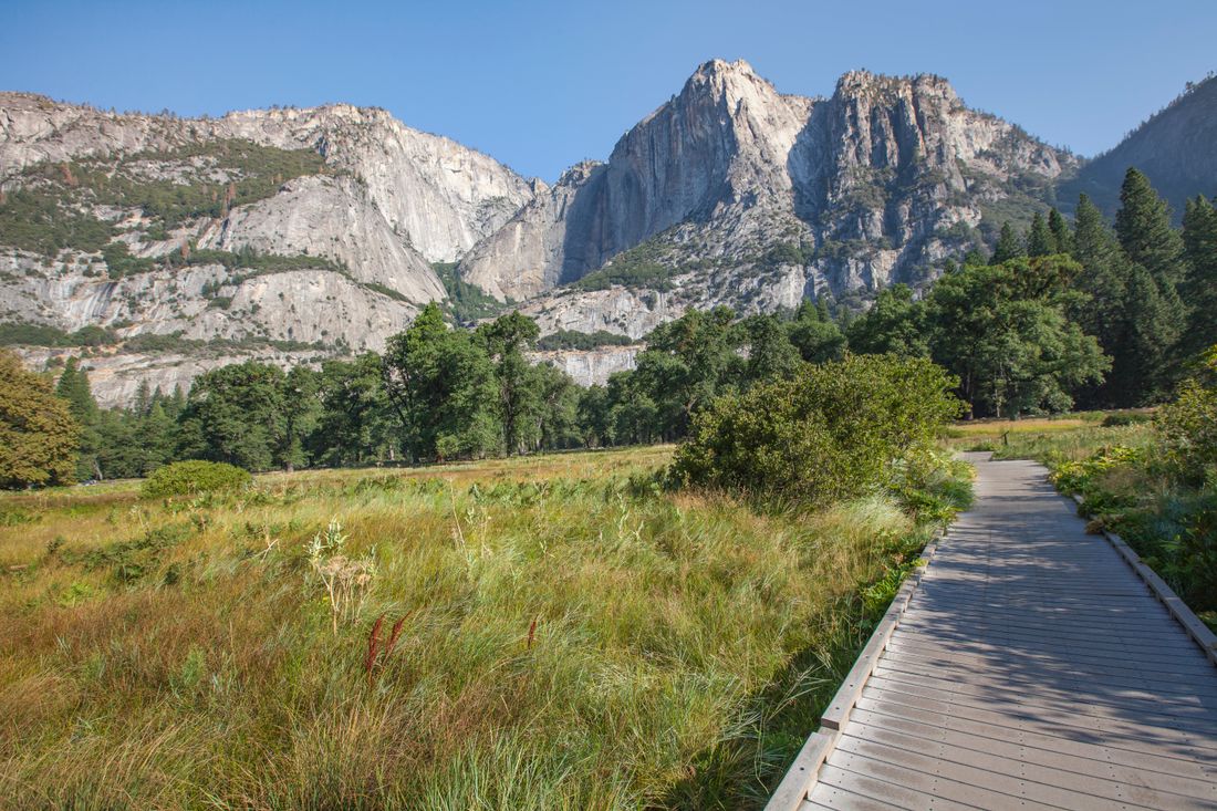 A wooden pathway and mountain landscape in Yosemite National Park.